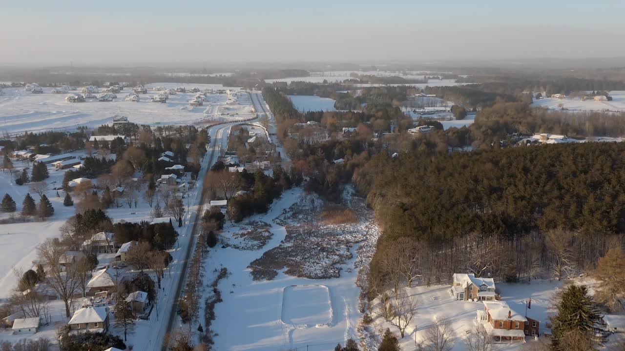 Aerial Pull Back Shot Of The Alton Mill And Neighborhood At Sunrise During Winter In Caledon, Canada.