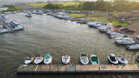 Ein-Langsamer,-Dramatischer-Luftschwenk-Links-Vom-Pier,-Während-Eine-Dreiköpfige-Familie-Bei-Sonnenuntergang-Am-East-Islip-Marina---Park-Nach-Links-Geht