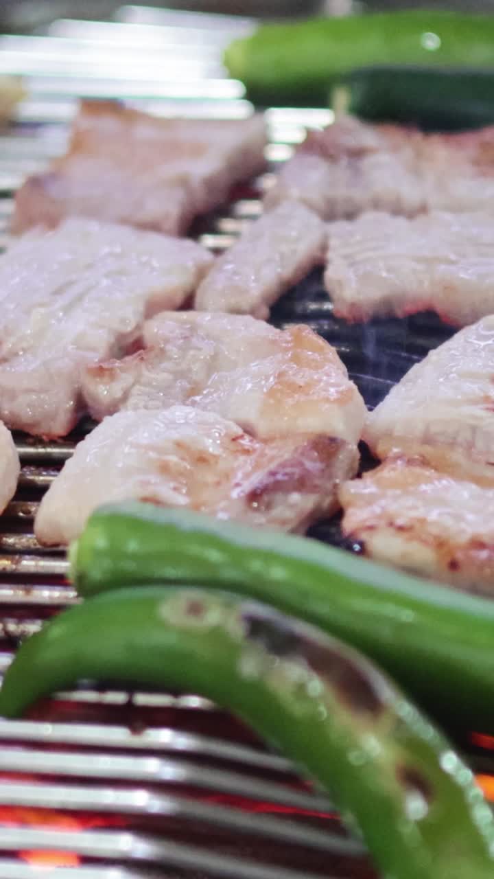 마늘 과 고추 를 넣은 그릴 에 돼지 배 를 요리 하는 것