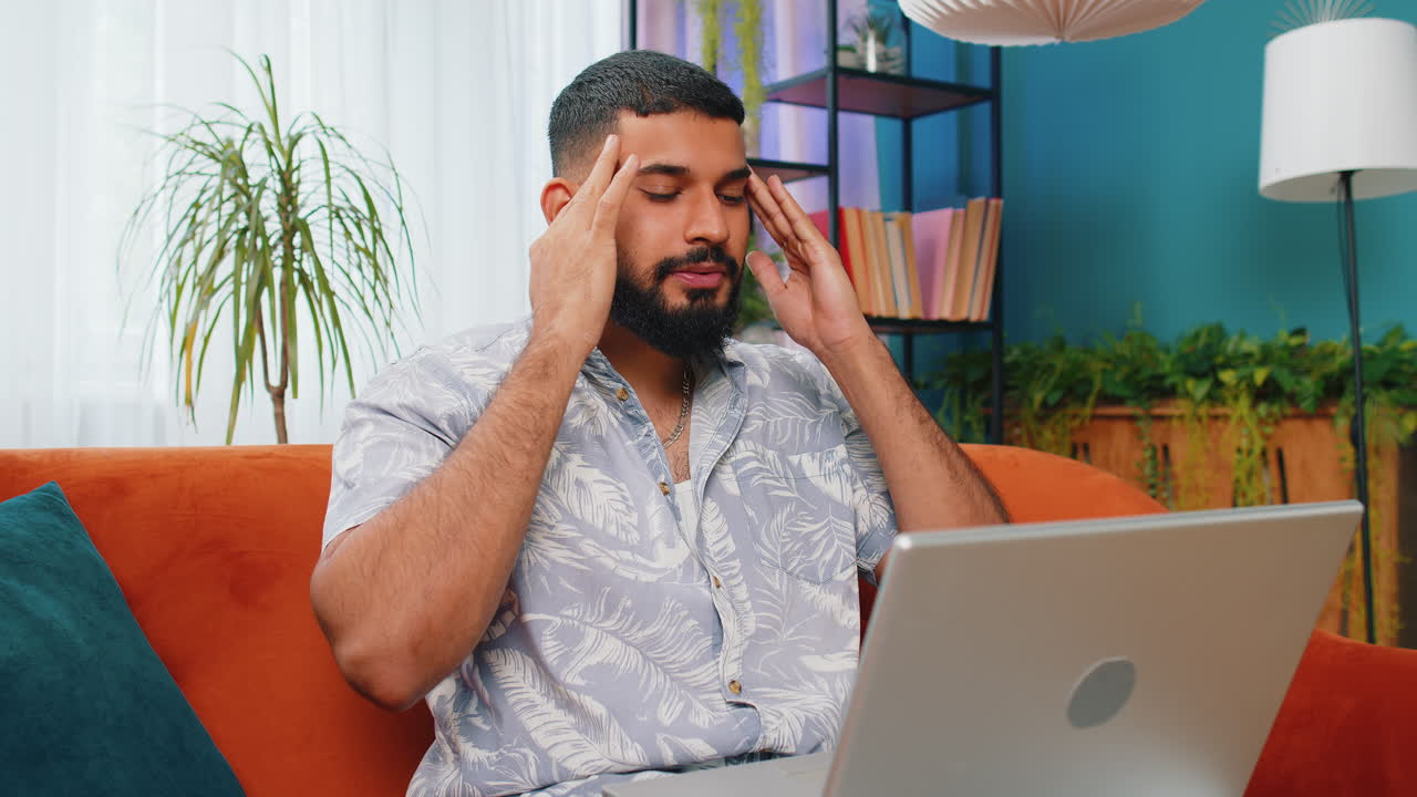 hombre trabajando en una computadora portátil desde casa