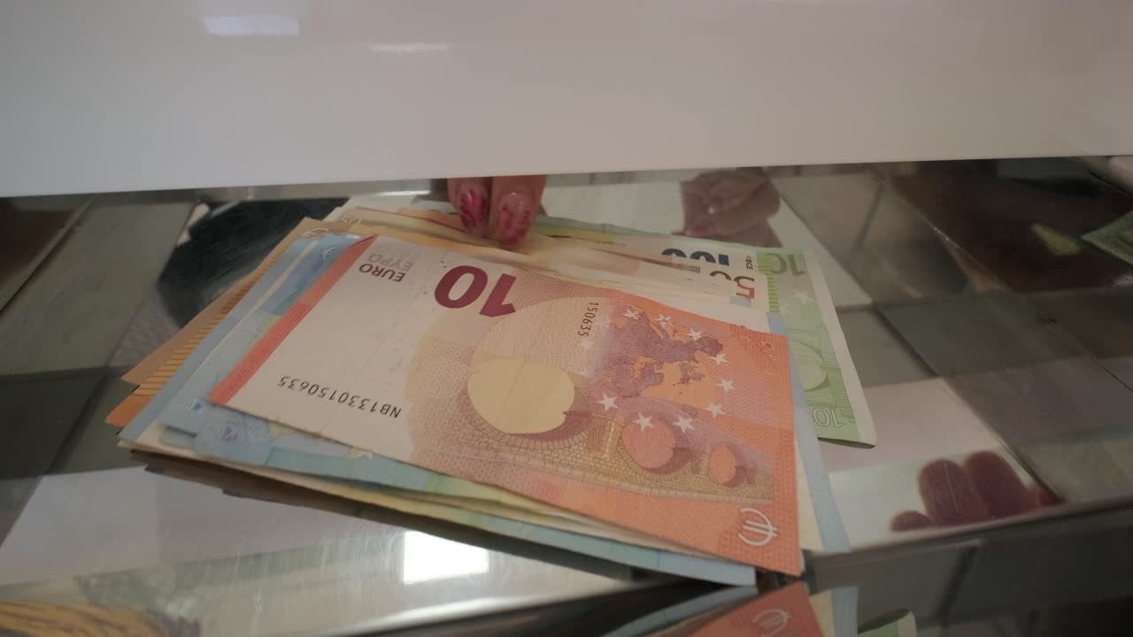 Hand Delivering Banknotes to Cash Register for Exchang