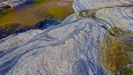 Early-morning-slow-tilt-up-of-Sabino-Waterfall,-creek,-and-lush-surroundings-in-Sabino-Canyon,-Arizona