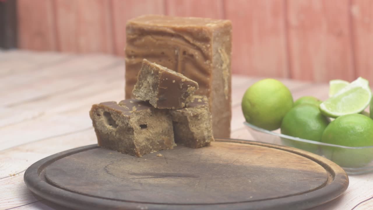 Kırsal mutfak ortamında, tahta üzerinde açık halde dönen kireç ve jaggery