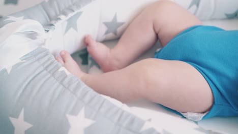 un niño lindo con las piernas desnudas descansa en un capullo con patrones de estrellas