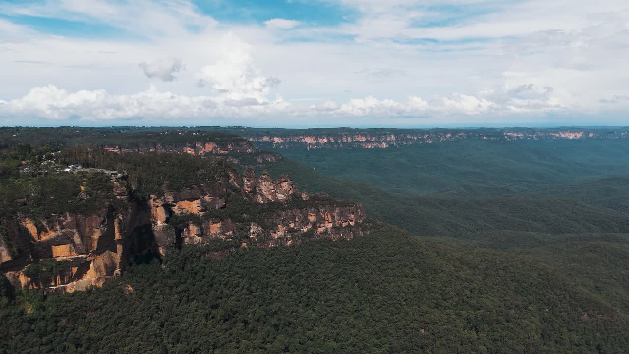 Smooth forward drone flight approaches the iconic Three Sisters sandstone peaks in Australia’s Blue Mountains National Park, revealing sheer cliffs, eucalyptus forest, and sweeping valley views.