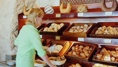 attractive woman chooses bread at the cafe with self-service