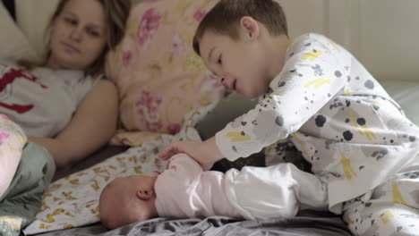 boy with newborn sister at home in the morning