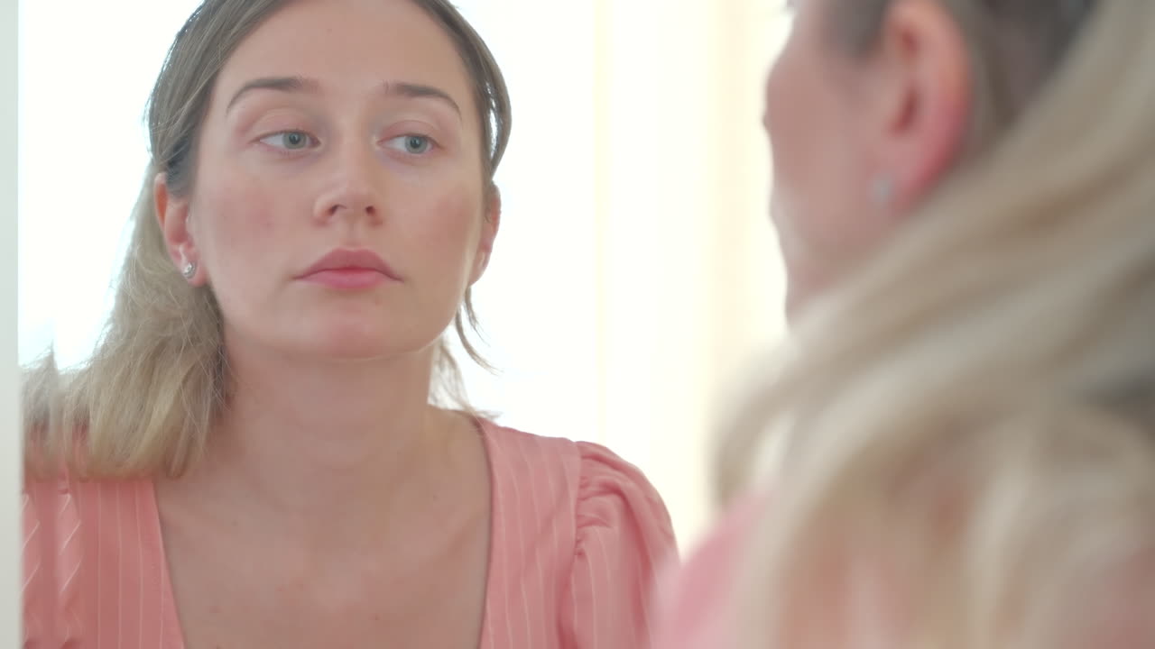 Close up of a woman putting on earrings in the mirror