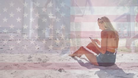 animación de la bandera de los estados unidos de américa sobre una mujer caucásica que usa un teléfono inteligente en la playa
