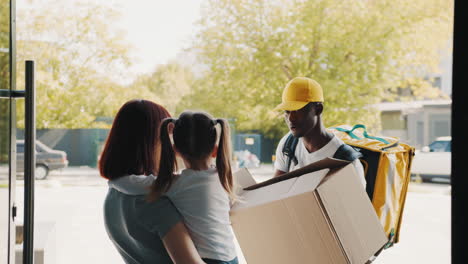 Delivery Person Delivering Package to a Family