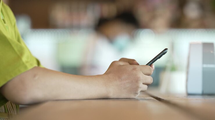 close up man checking email with cell phone at a coffee shop