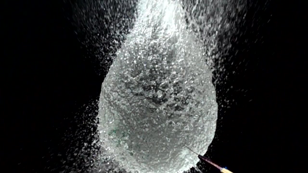Un pallone d'acqua su sfondo nero. Acqua a forma di sfera