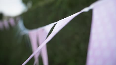 pink flag decoration haging on a garden party outside in summer