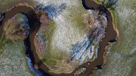 Una-Vista-Aérea-De-La-Flecha-Torcida-Del-Río-Que-Corre-A-Través-De-Los-Campos-En-Warwickshire,-Inglaterra-En-Una-Soleada-Mañana-Helada-De-Invierno