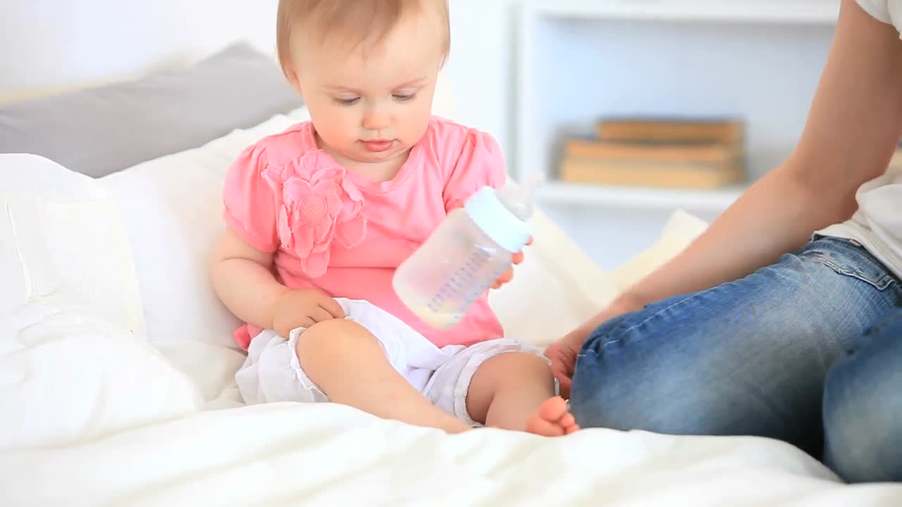 Bambino piccolo che gioca con il suo biberon