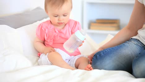 Toddler-playing-with-her-baby-bottle