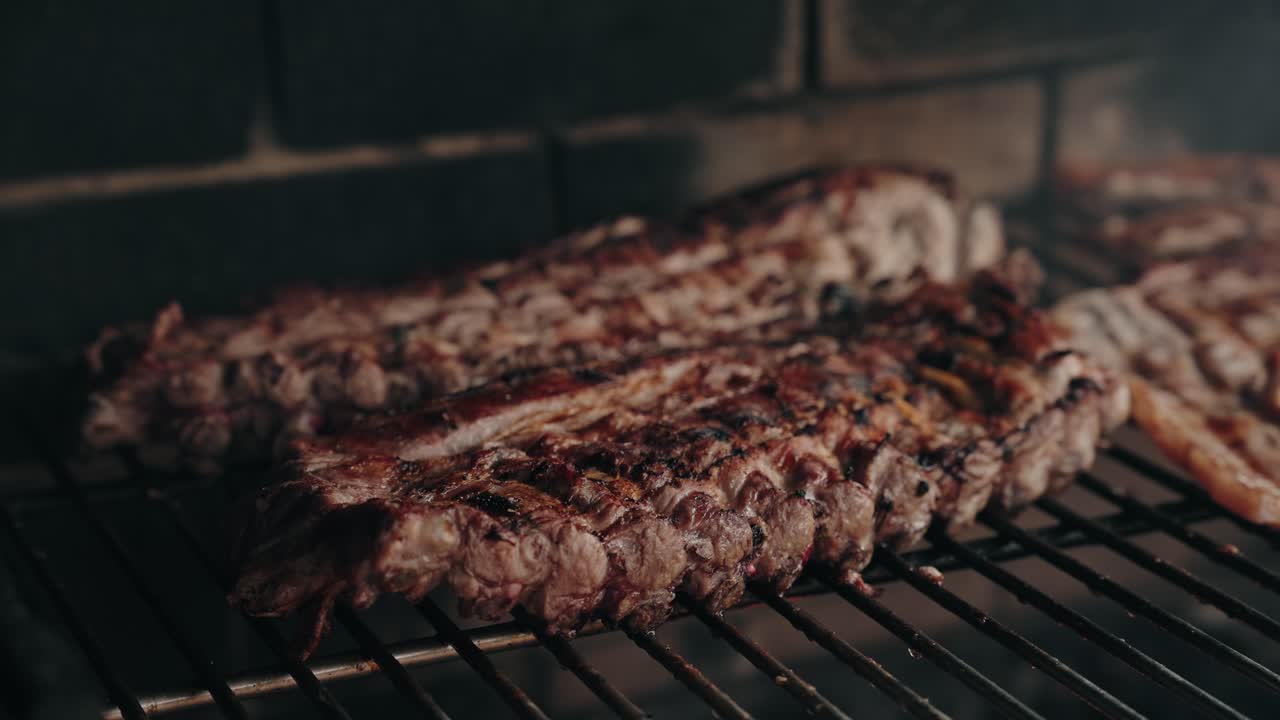 Close up juicy pork ribs sizzling on barbecue grill over open flame