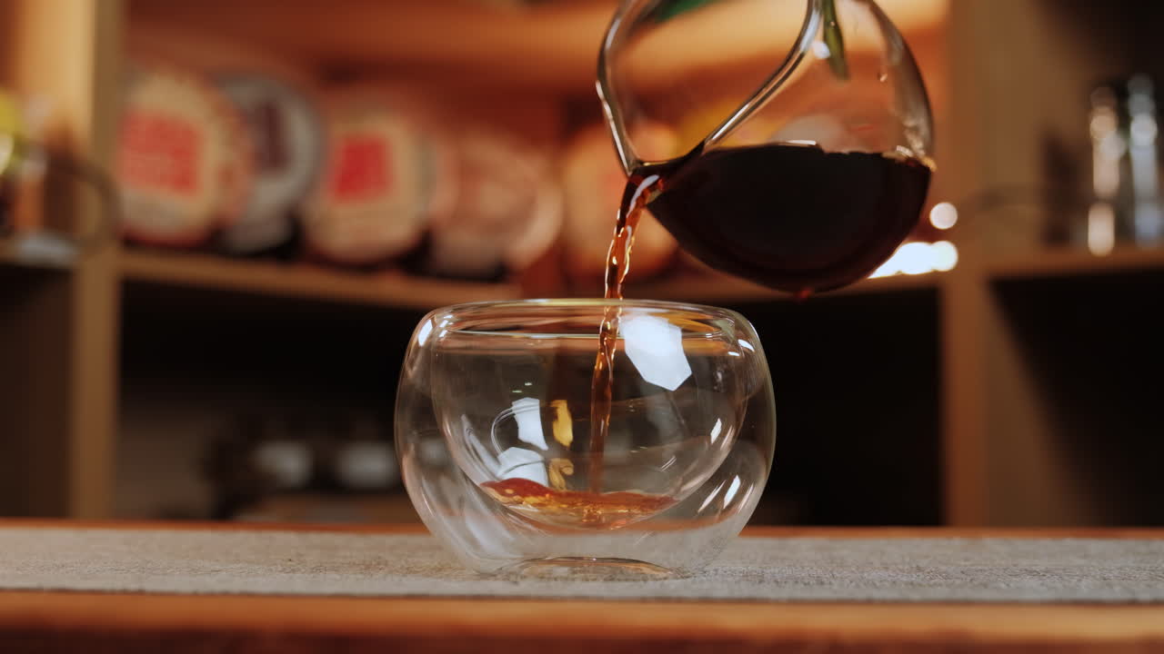 차나 커피를 이중 벽의 유리 컵에 부어 넣는 것