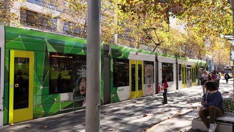 a tram moves through a busy melbourne street