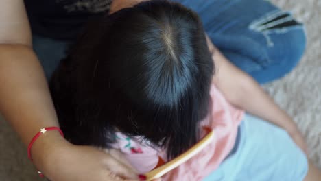 mother combing daughter's hair