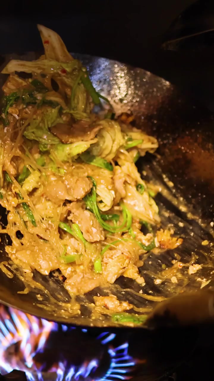 Chef salta in padella sukiyaki thailandese con verdure in un wok caldo su fiamma viva