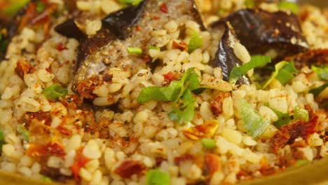 bulgur with eggplant and greenery close-up rotation. traditional middle eastern culture. delicious rice with meat. arabian cuisine. homemade food concept