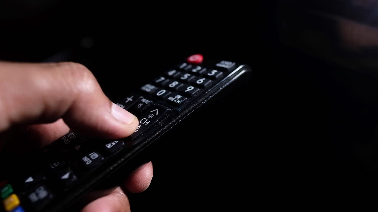 tv 리모컨을 들고 있는 손