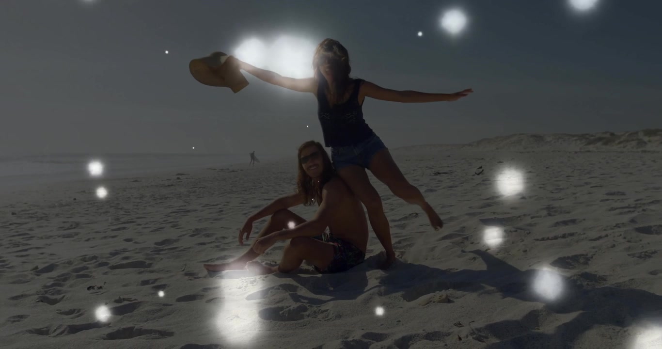Donna che tiene un cappello di paglia da sole e inizia una posa di equilibrio con un uomo che indossa occhiali da sole in spiaggia, per un viaggio.