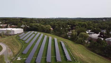 Descending-view-of-solar-farm-installation,-starting-with-Boston-skyline