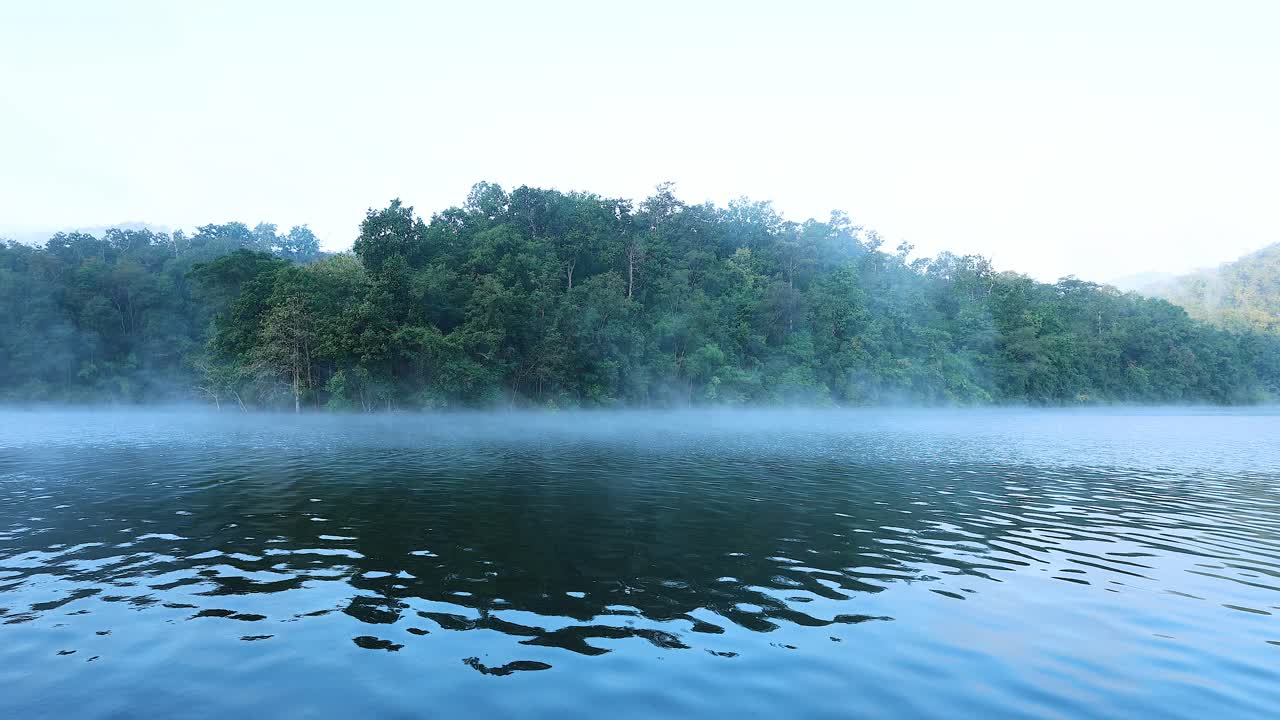 안개와 숲이 인 언덕이 있는 조용한 강