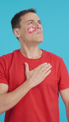 Man listening to the Switzerland national anthem with solemnity