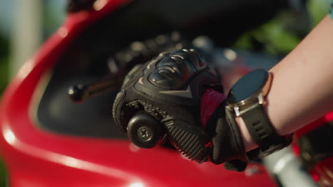 close-up of a biker s hand wearing protective gloves, removing fingers from the clutch lever as the motorcycle moves forward and backward, a smartwatch is visible on the wrist