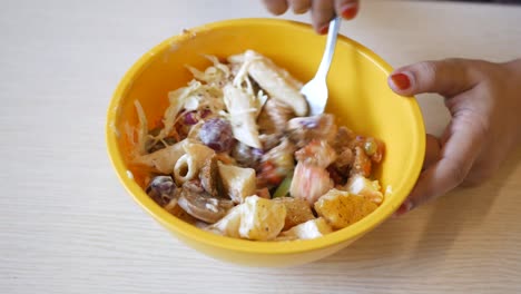 person eating a pasta salad