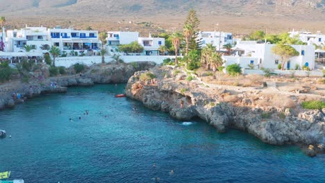 side view of intrepid people jumping from the cliff in avlemonas, greece