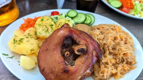 pork, sauerkraut, and potatoes on a plate at a restaurant