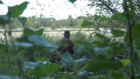 Hunter-hiding-in-green-grass-and-foliage,-Cinematic-slow-motion-with-shallow-depth-of-field