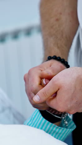 male hands performing massage on female hand. husband helping his pregnant wife to relax. close up. vertical video