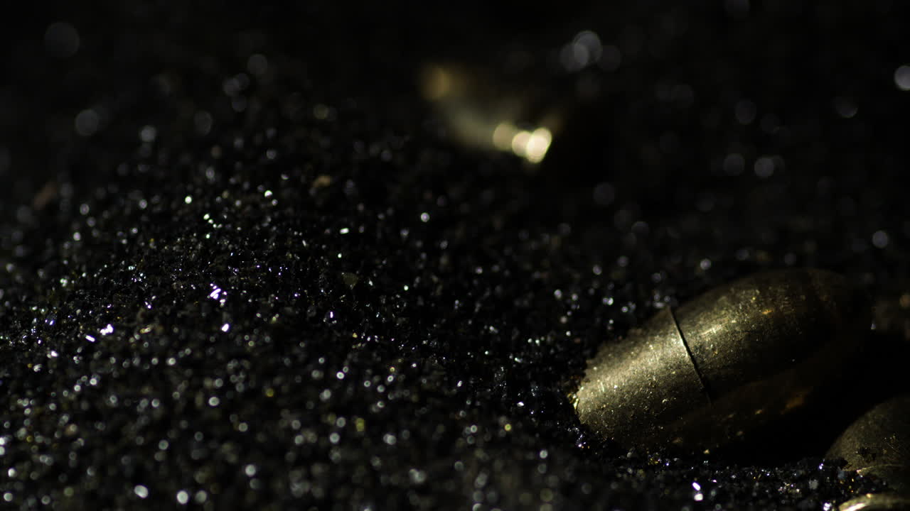9×19mm Parabellum bullets macro detail closeup shot fall on gunpowder, slowmo