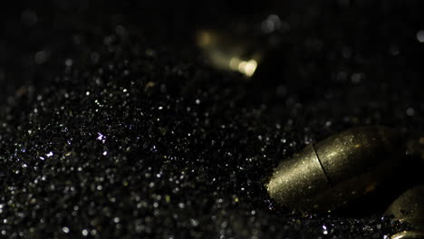 9×19mm parabellum bullets macro detail closeup shot fall on gunpowder, slowmo