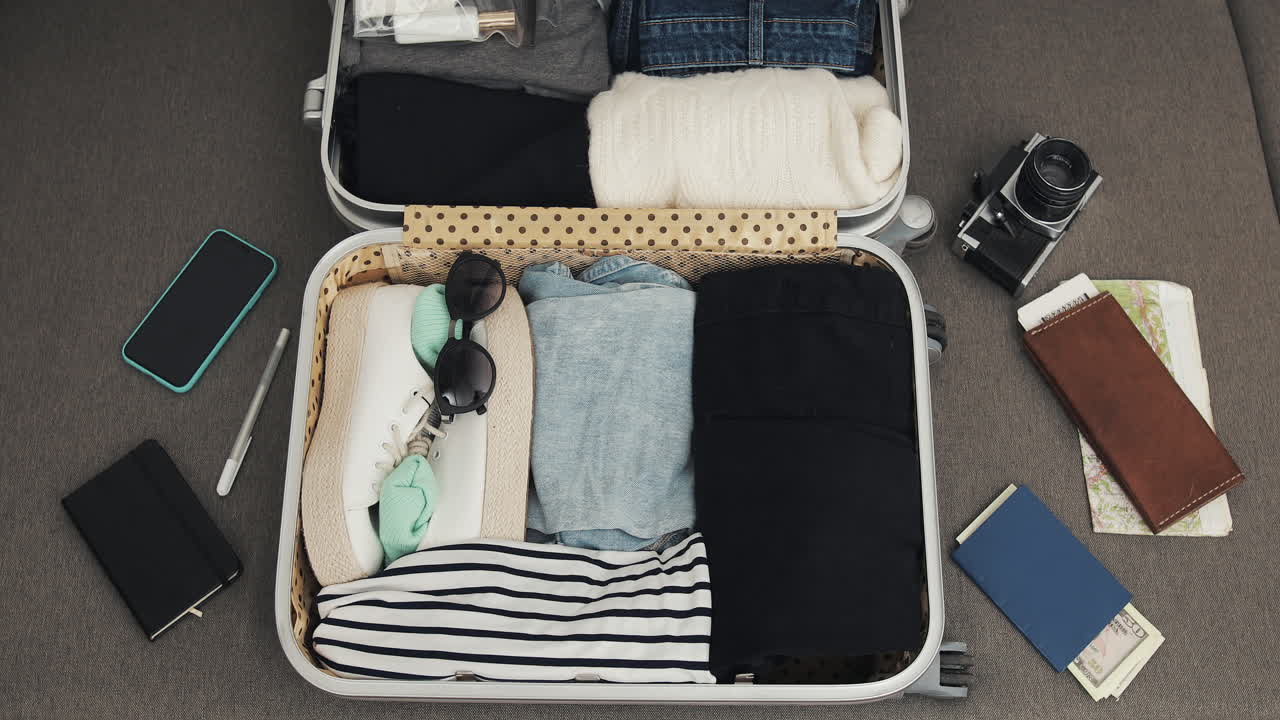 Open suitcase with packed clothing and travel accessories