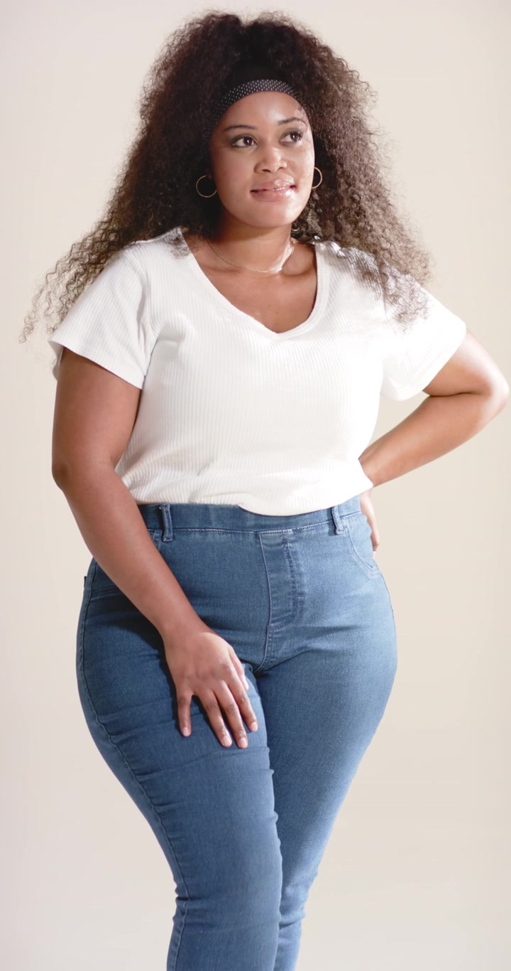 Video verticale: La telecamera panoramica rivela una donna afroamericana che posa e gira la testa in studio.