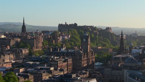 smooth cinematic drone footage with parallel movement showcasing edinburgh’s castle, the elegant balmoral clock tower, and the towering scott monument in a breathtaking cityscape
