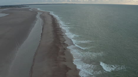 Hermosa-Costa-De-La-Playa-Del-Norte-De-Bélgica-En-Puesta-De-Sol-Nublada,-Avance-Aéreo