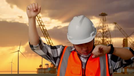 primer plano de ingeniero masculino asiático con casco de seguridad gritando gol y bailando celebrando con la producción de hidrógeno en alta mar