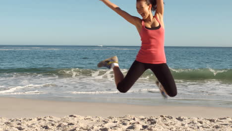 mujer corriendo y saltando en la playa