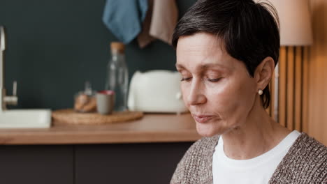 elderly woman eating a healthy salad in her kitchen
