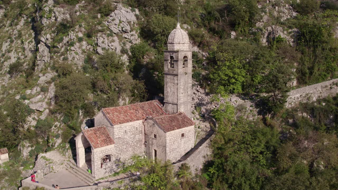 Chiesa, montagna, foresta e sentiero in pietra nella città medievale della Baia di Cattaro, ripresa aerea.