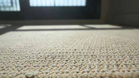 close-up of woven carpet with window light