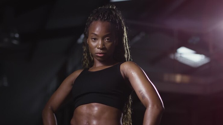Studio-Porträt einer Frau in Sportkleidung, stehend im Fitnessstudio 4