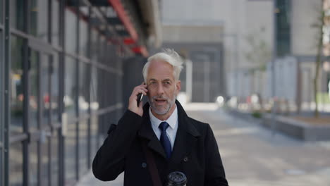 portrait successful middle aged businessman using smartphone answering phone call enjoying talking conversation on mobile phone professional entrepreneur chatting in city slow motion